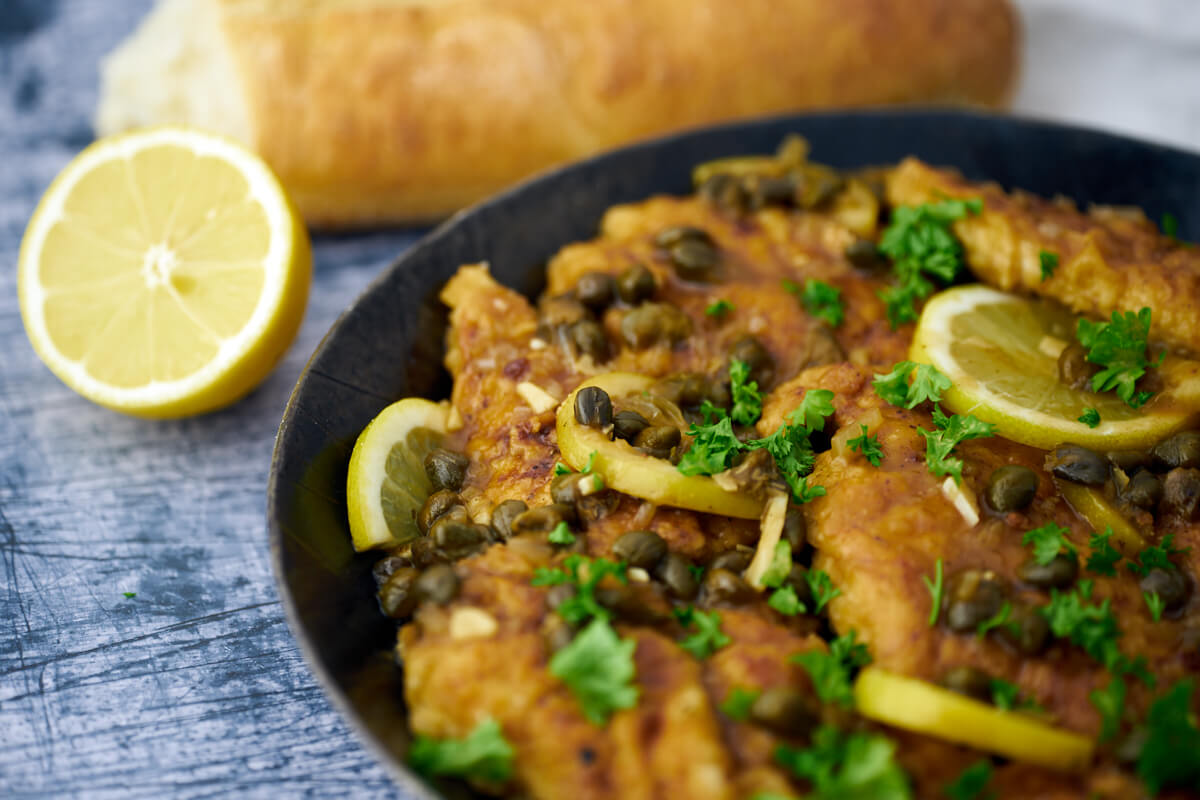 chicken piccata in frying pan with bread