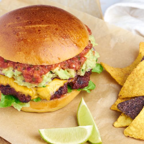 mexican burger with guacamole and salsa served with nachos chips
