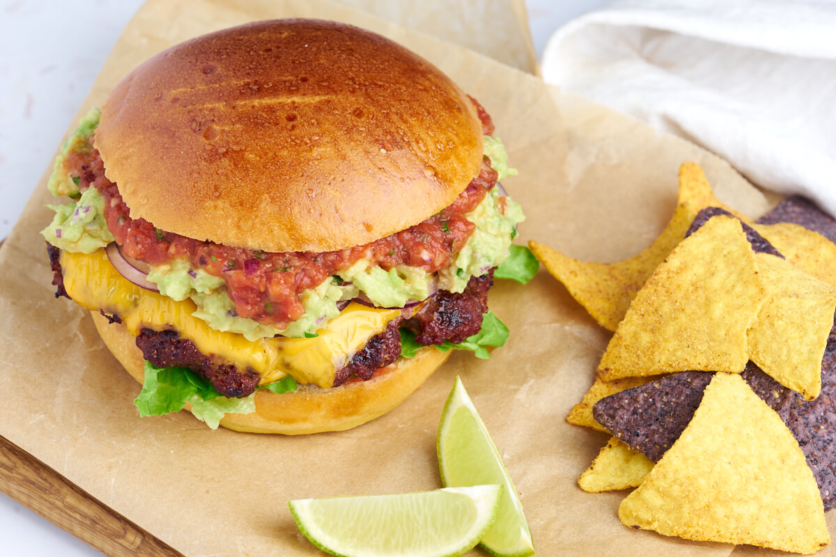 mexican burger with guacamole and salsa served with nachos chips