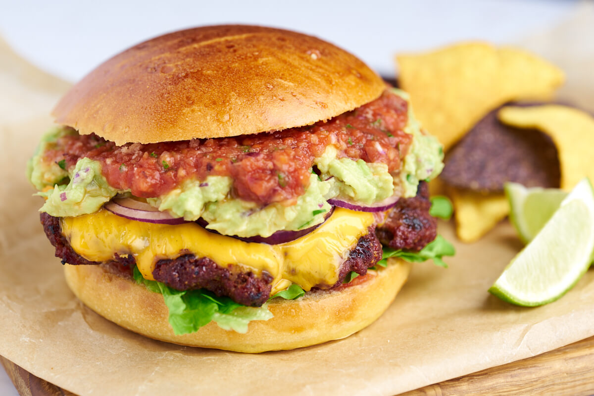 Mexican burger or taco burger with guacamole, salsa and cheese
