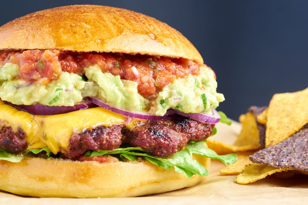 juicy mexican burger with guacamole and salsa and cheese