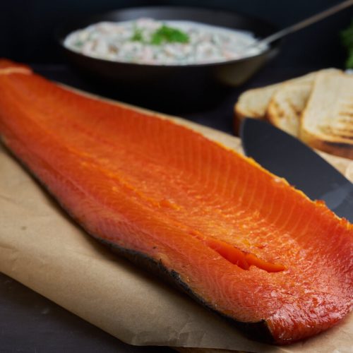 cols smoked salmon on wooden board with bread and prawns