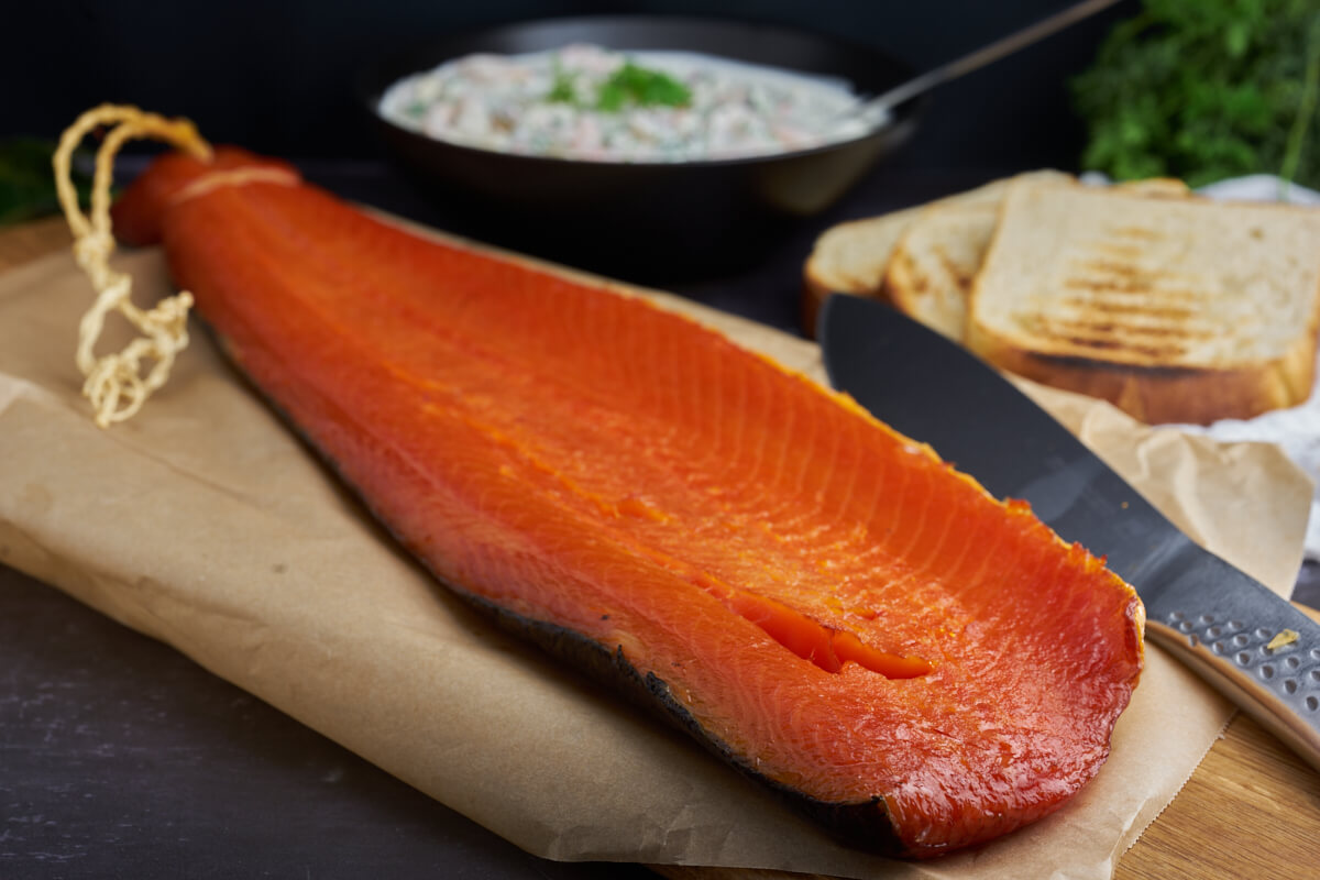 cols smoked salmon on wooden board with bread and prawns