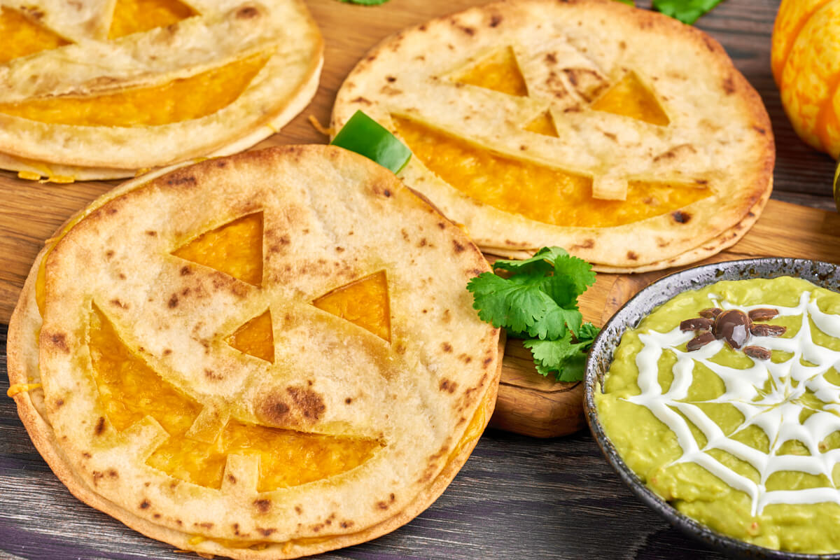 Jack o lantern quesadillas with spider guacamole dip for halloween