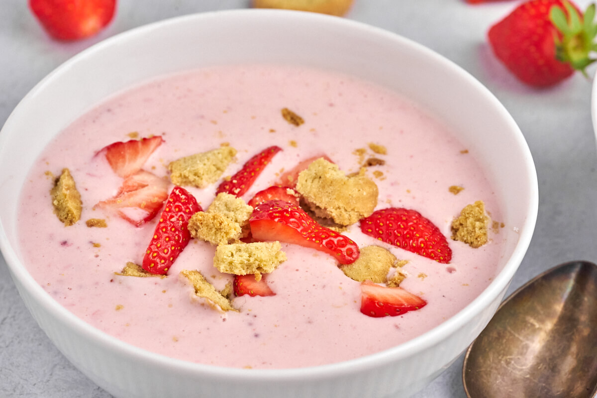 bowl with danish cold strawberry buttermilk soup topped with kammerjunkere and fresh strawberries