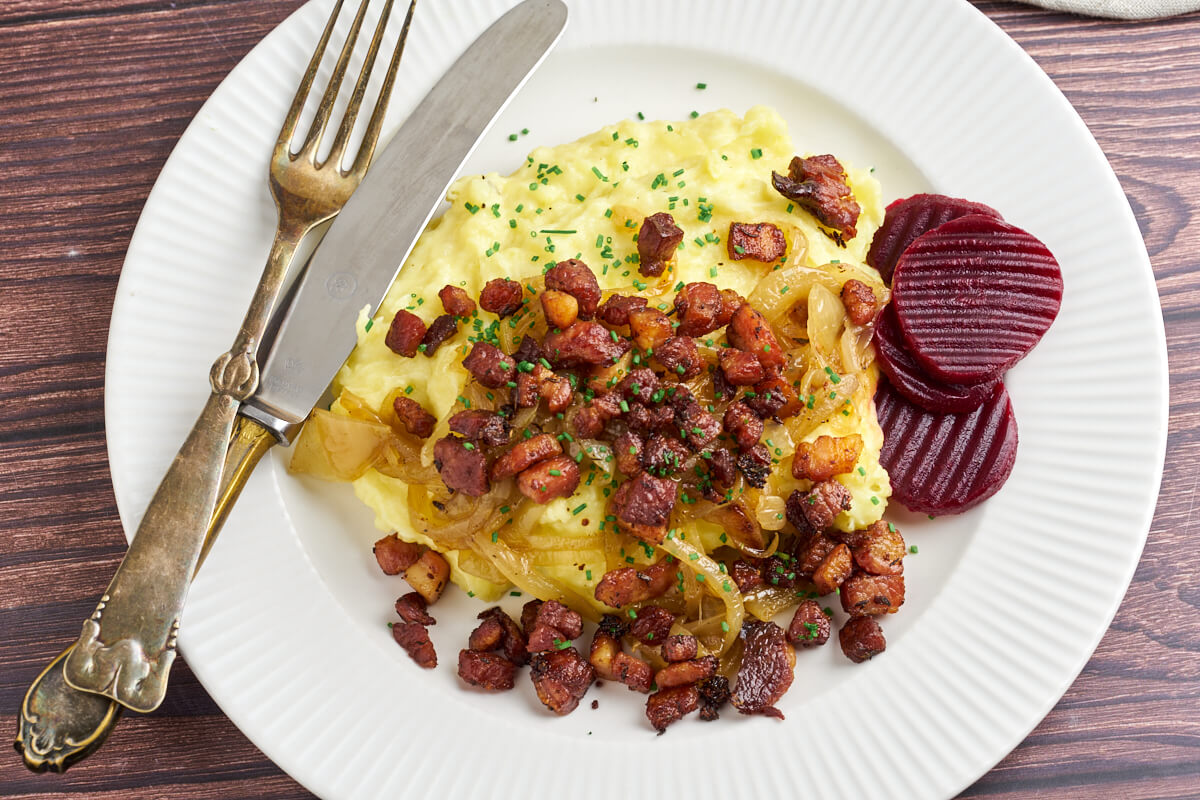 plate with danish burning love with mashed potatoes, bacon and onion served with pickled beets