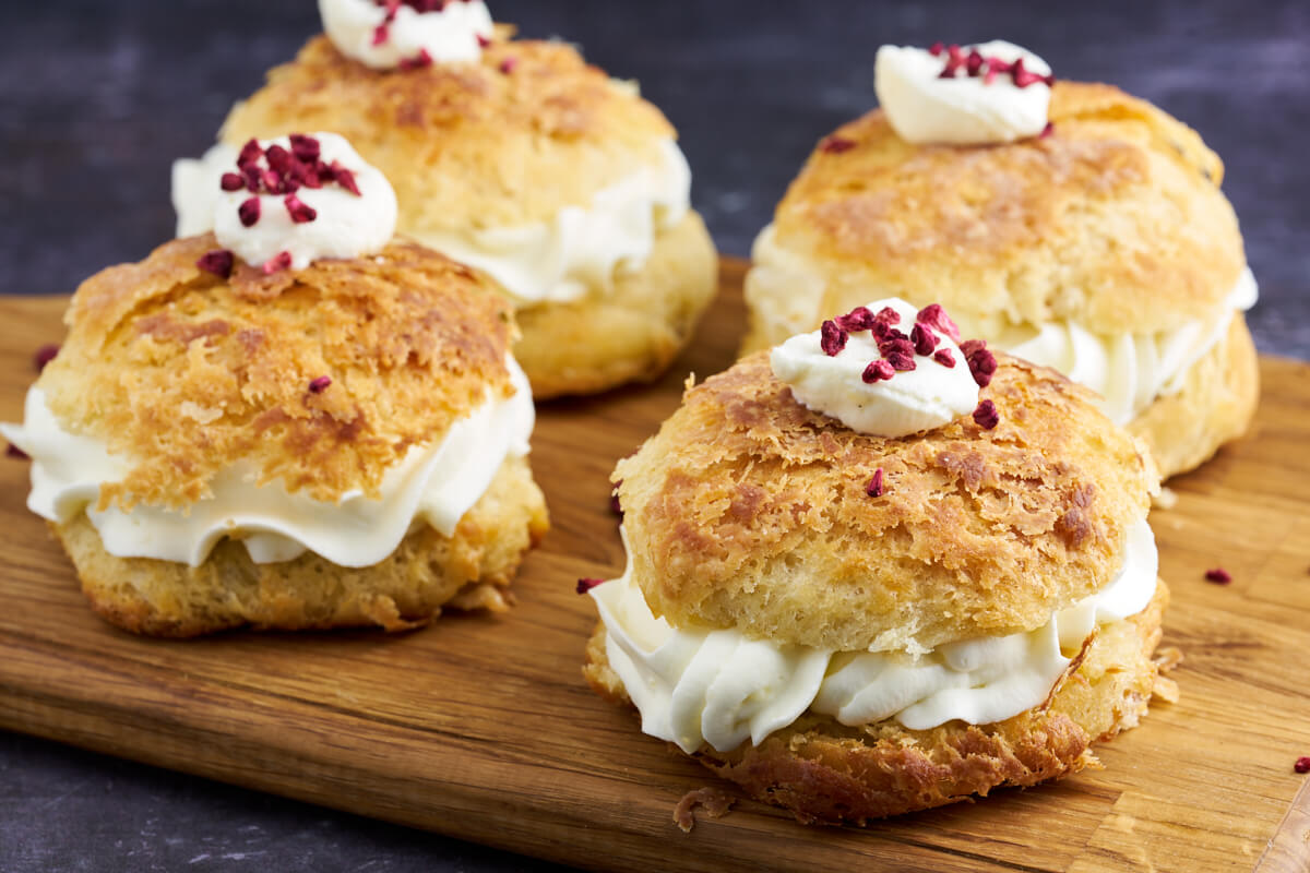 four danish shrovetide buns or fastelavnsboller with pastry cream and jam