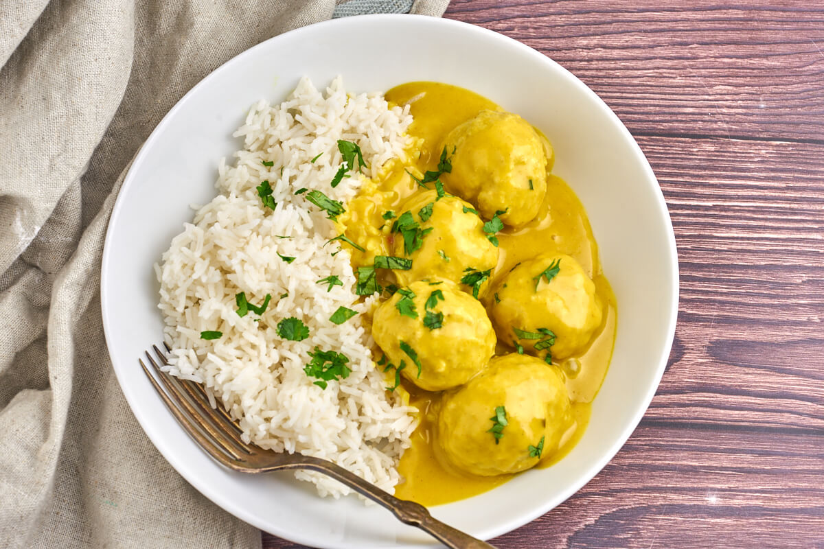 dish with danish meatballs in curry sauce served with white rice