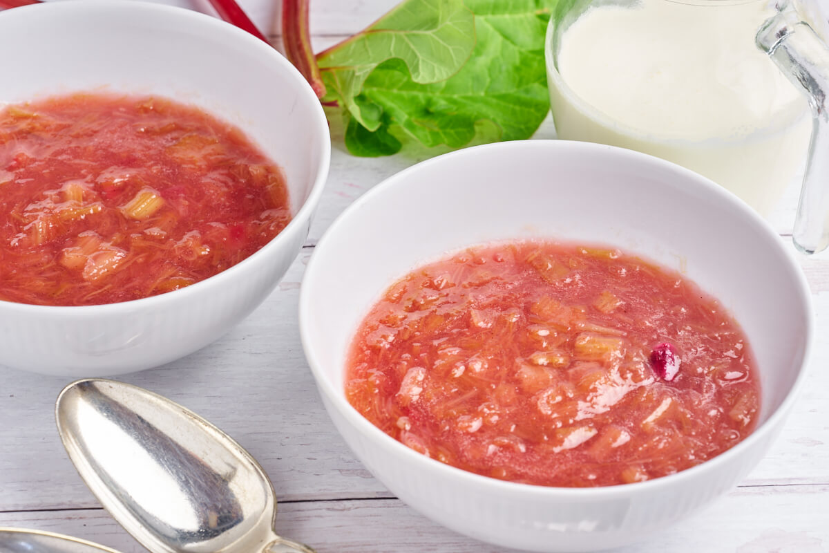 red rhubarb pudding served with cream and almonds