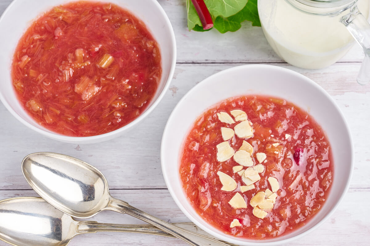 two bowls of danish rhubarb pudding with almonds and cream