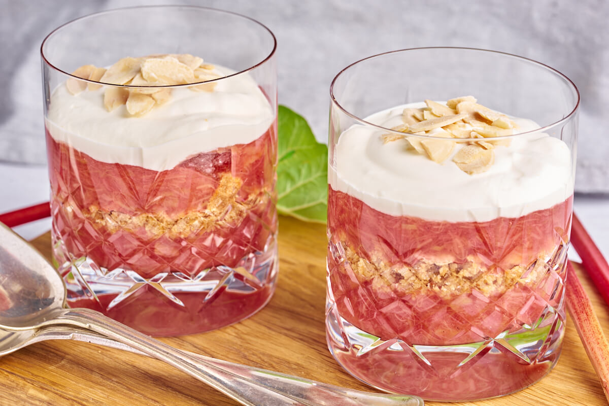 two glasses of old-fashioned danish rhubarb cake with whipped cream and almonds