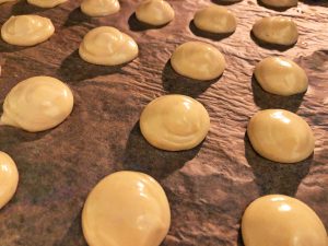 profiteroles piped out on a baking tray