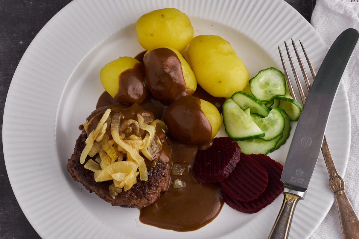 danish ground beef patty with gravy, soft onions and potatoes served with Danish cucumber salad and pickled beets