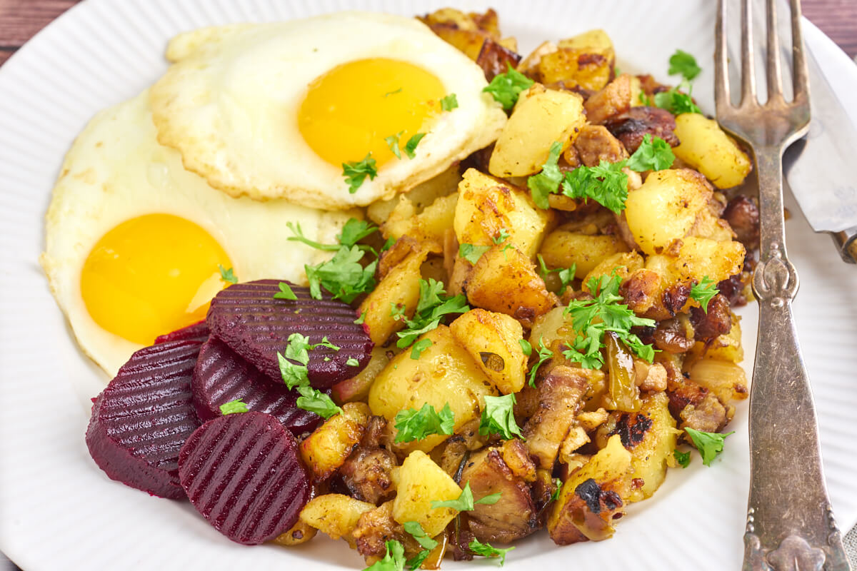 Danish potato hash with pork roast with fried eggs and pickled beets