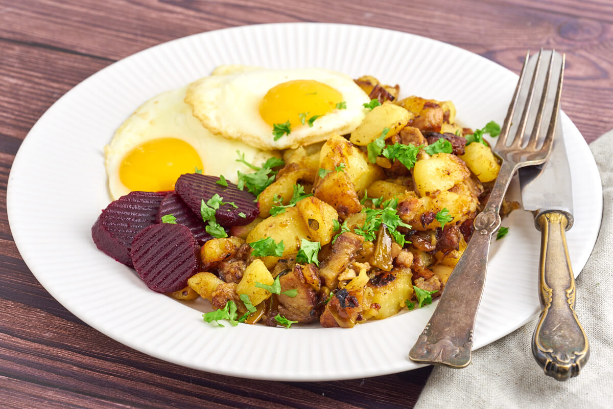 Danish hash with pork served with fried eggs and pickled beets