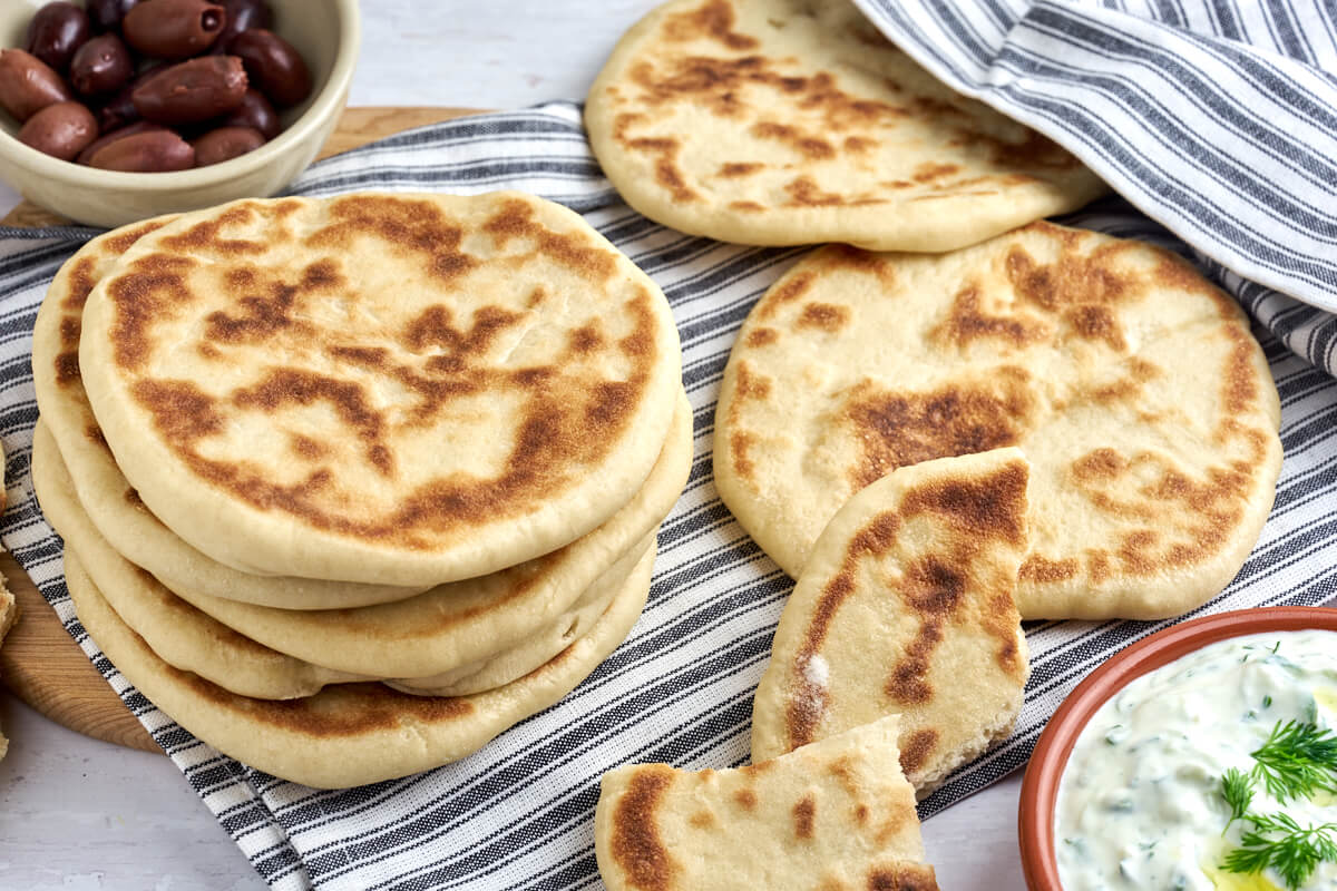 greek food with pita bread, olives and tzatziki