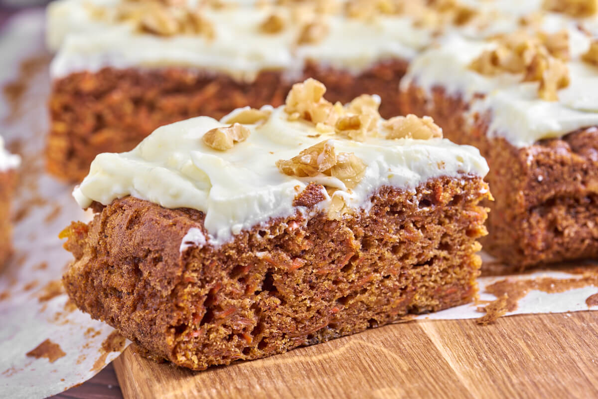 slice of carrot cake with cream cheese frosting and walnuts
