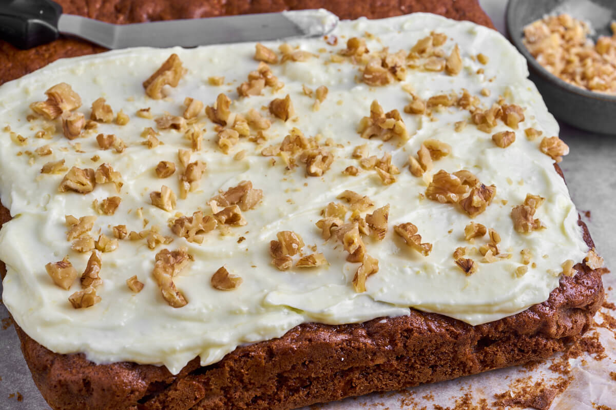 whole sheet of carrot cake with cream cheese frosting and walnuts