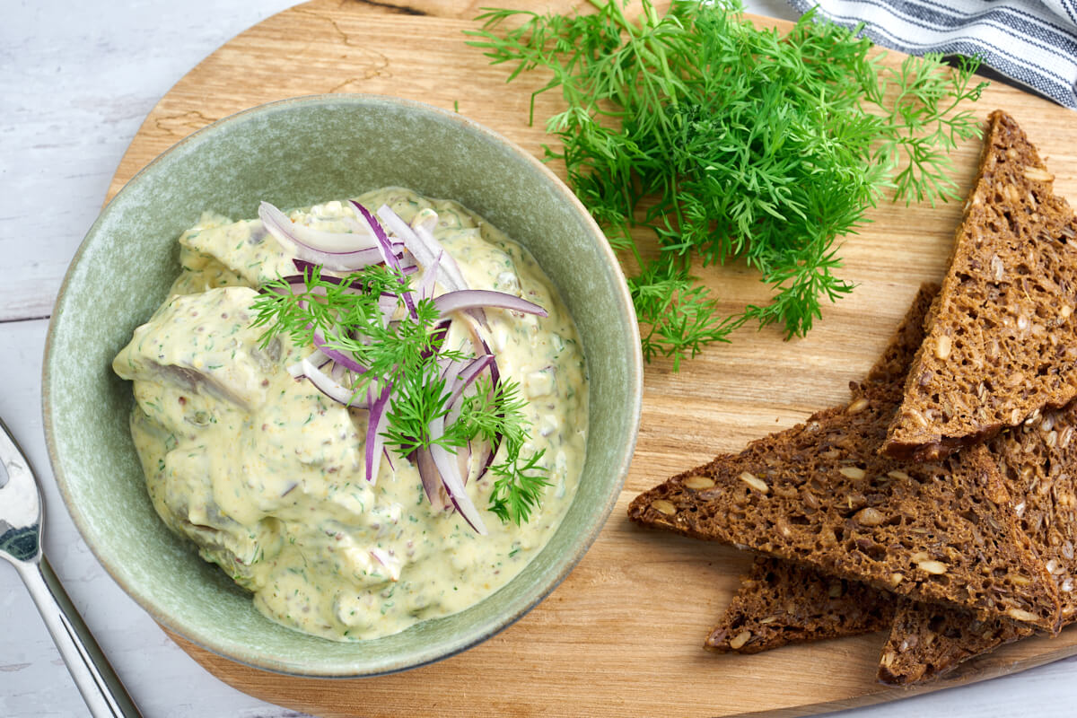 danish marinated herring in mustard sauce for easter lunch with rye bread