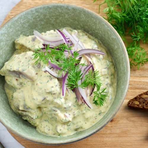 Danish or swedish pickled herring in mustard sauce served with rye bread