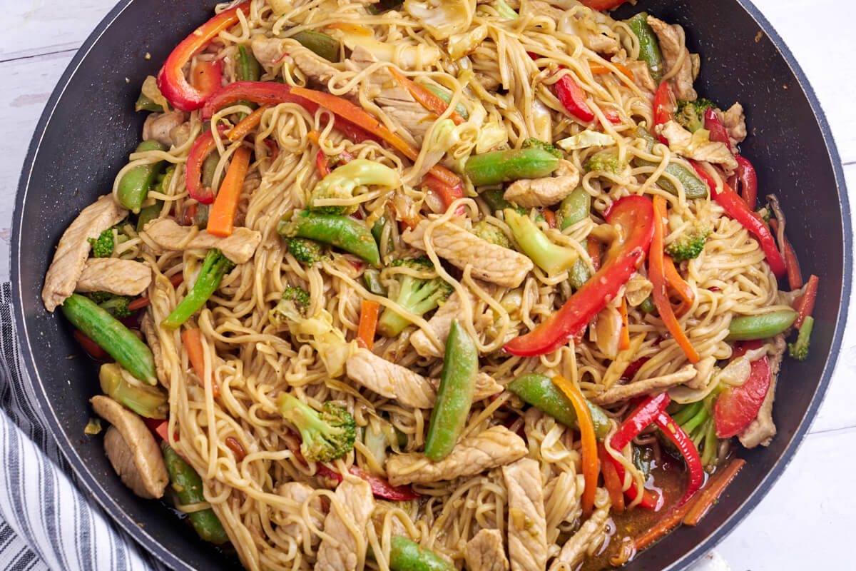 frying pan with pork lo mein with broccoli and bell pepper