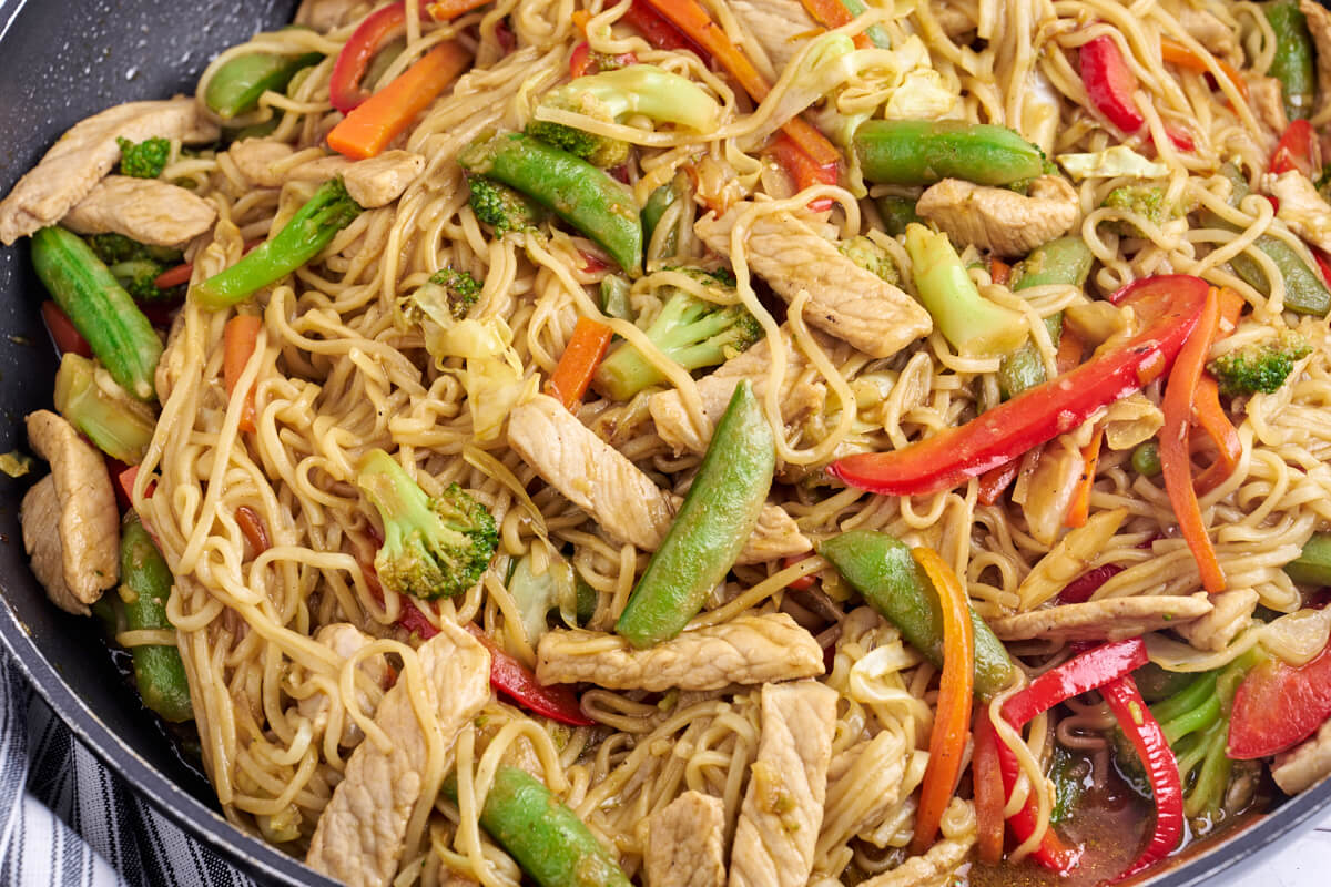 lo mein with pork and vegetables in frying pan