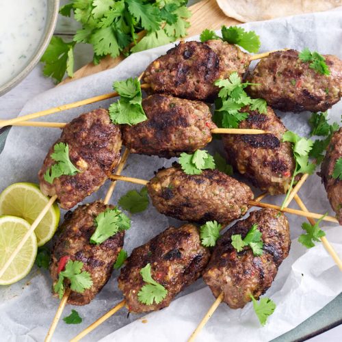 kofta skewers with cilantro and lime served with raita dip