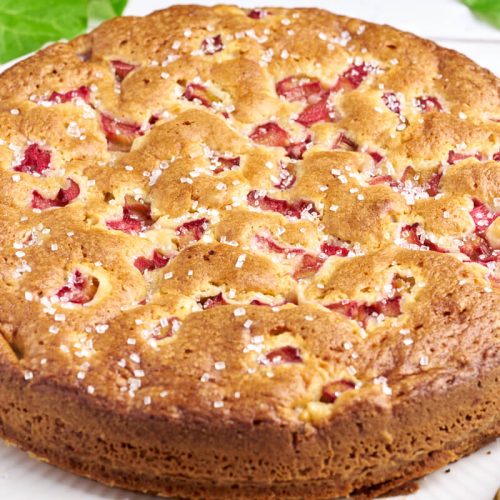 rhubarb cake on plate with knife and rhubarbs