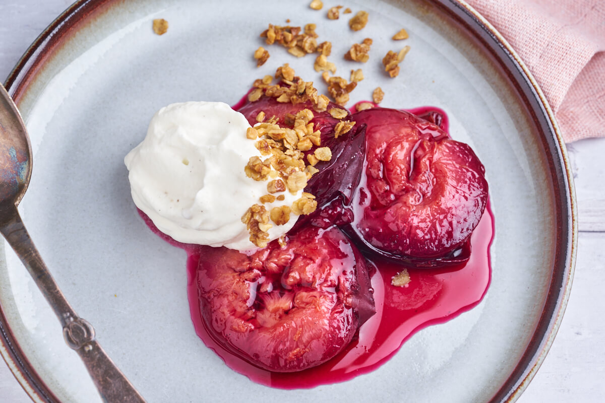 easy plum dessert with baked vanilla plums with whipped cream and almond oatmeal crumble