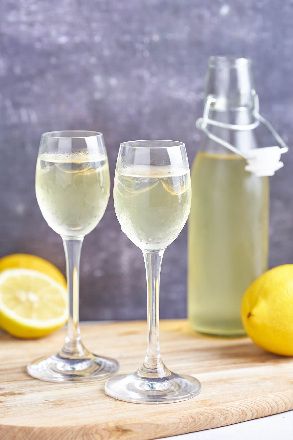 tall glasses with limoncello and lemon and a bottle