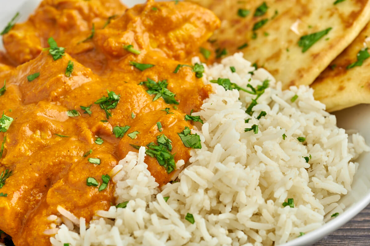 butter chicken with rice and cilantro on top