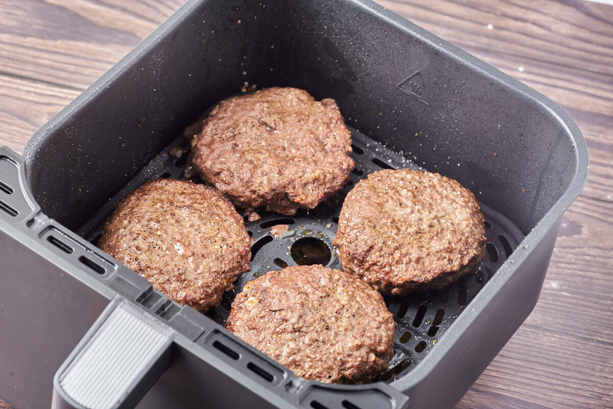 Air fryer basket with hamburgers