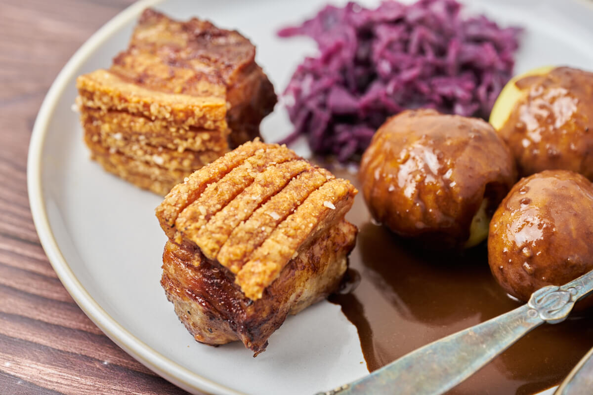 Danish pork belly serving the danish red cabbage, potatoes and gravy