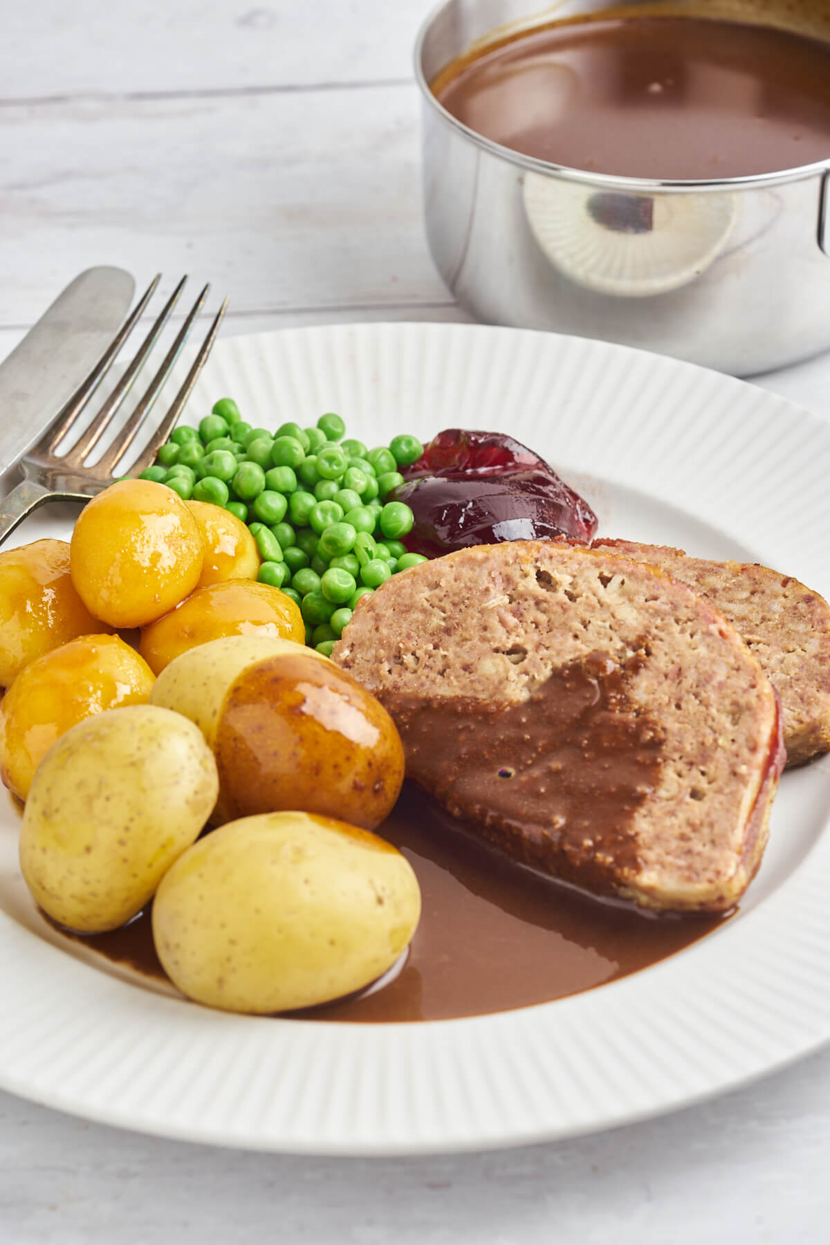 Danish meatloaf with gravy and potatoes on plate