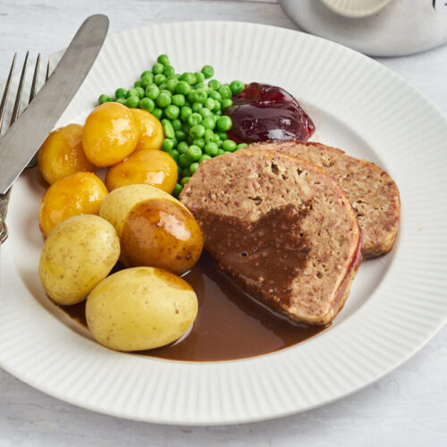 Danish meatloaf with gravy, potatoes, caramallized potatoes and green peas