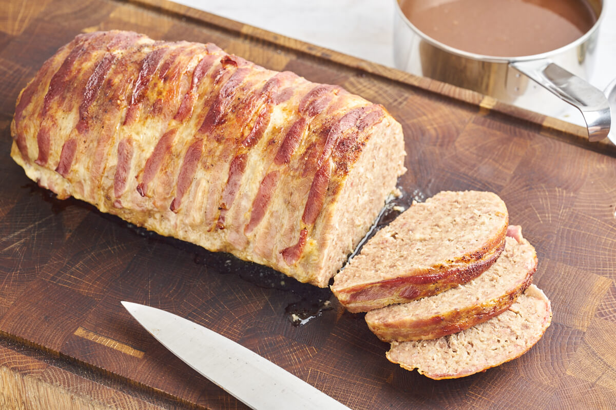 Danish meatloaf on cutting board and gravy