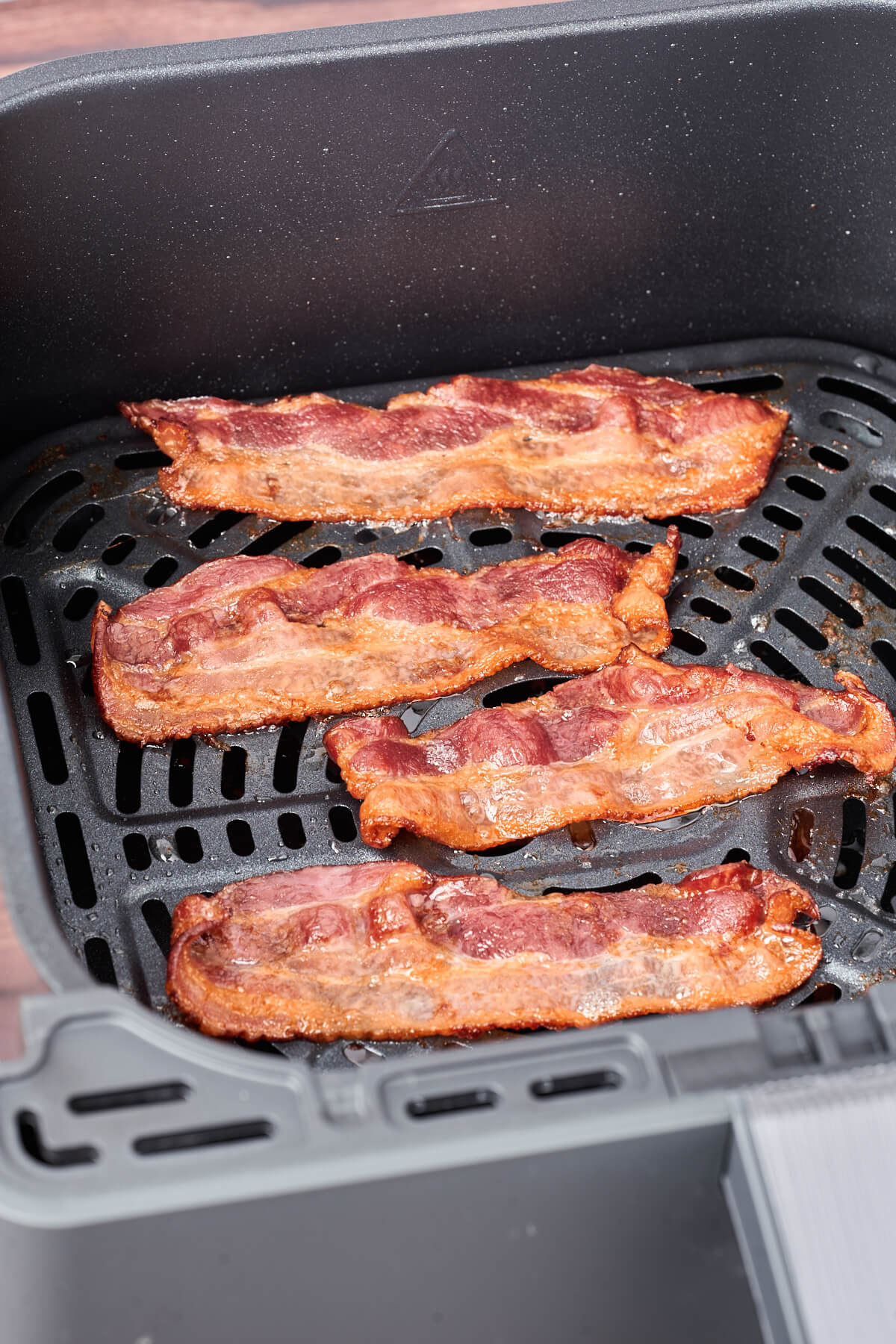 air fryer basket with crispy bacon in