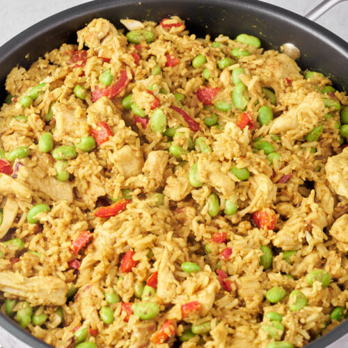 chicken fried rice with edamame beans and bell pepper in pan