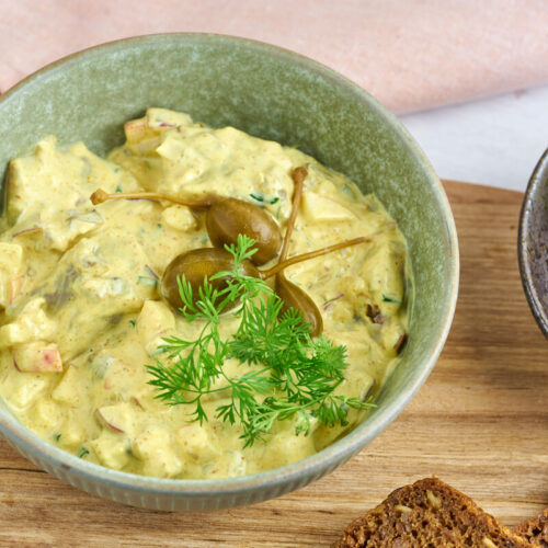 Danish curry herring or curried pickled herring served with hard boiled eggs and rye bread