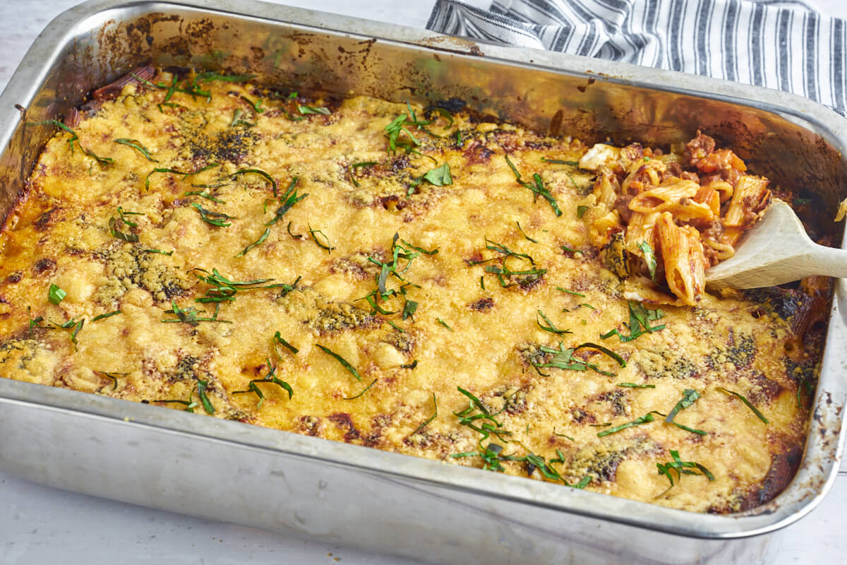 Italian lasagnette in ovenproof dish with wooden spoon