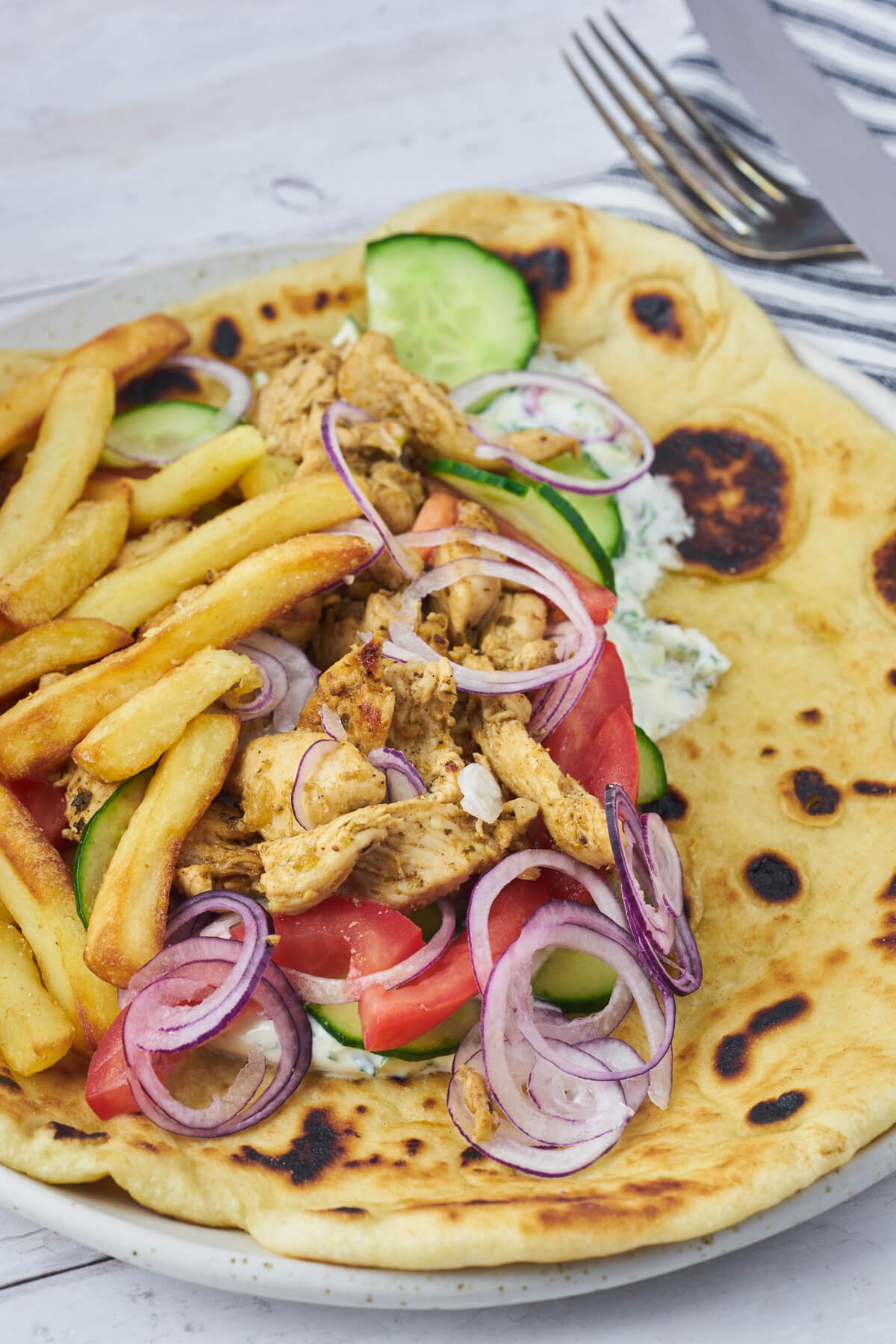 greek flatbread with chicken gyros, vegetables and tzatziki