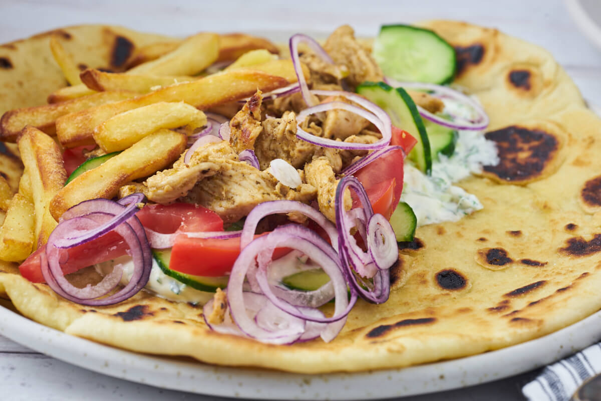 greek chicken gyros with fries, vegetables and tzatziki