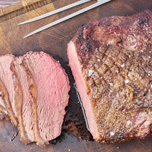 grilled top sirloin cap roast sliced on cutting board