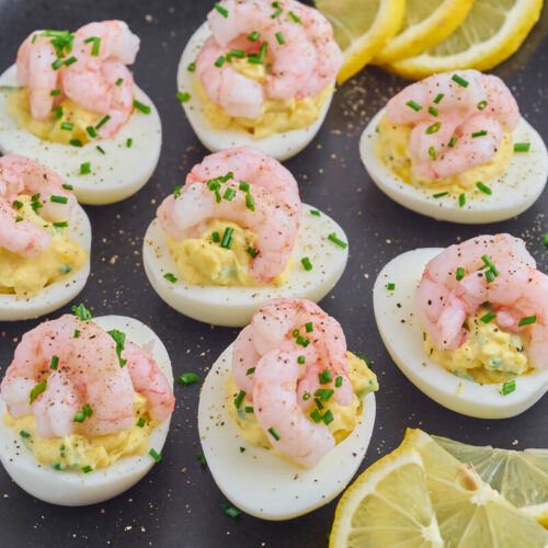 shrimp deviled eggs with lemon slices on plate