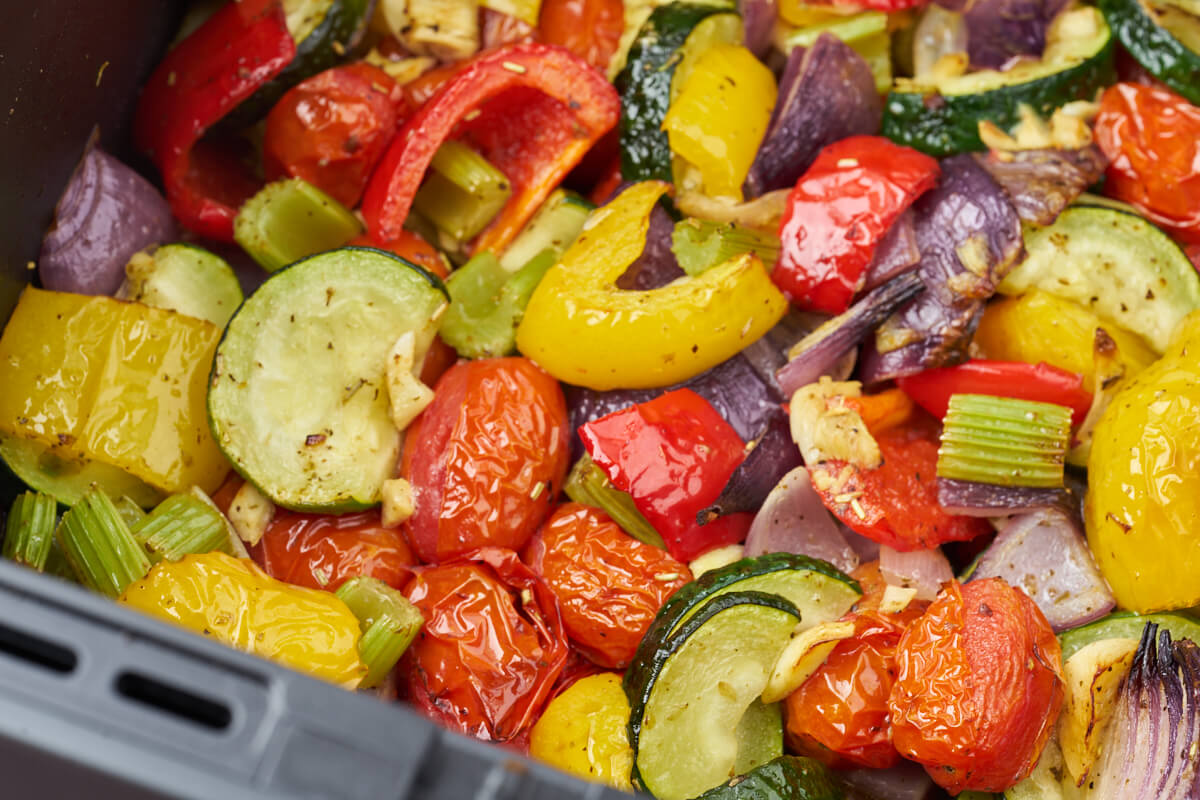 air fryer with tomatoes, squash, red onion, bell pepper and spices