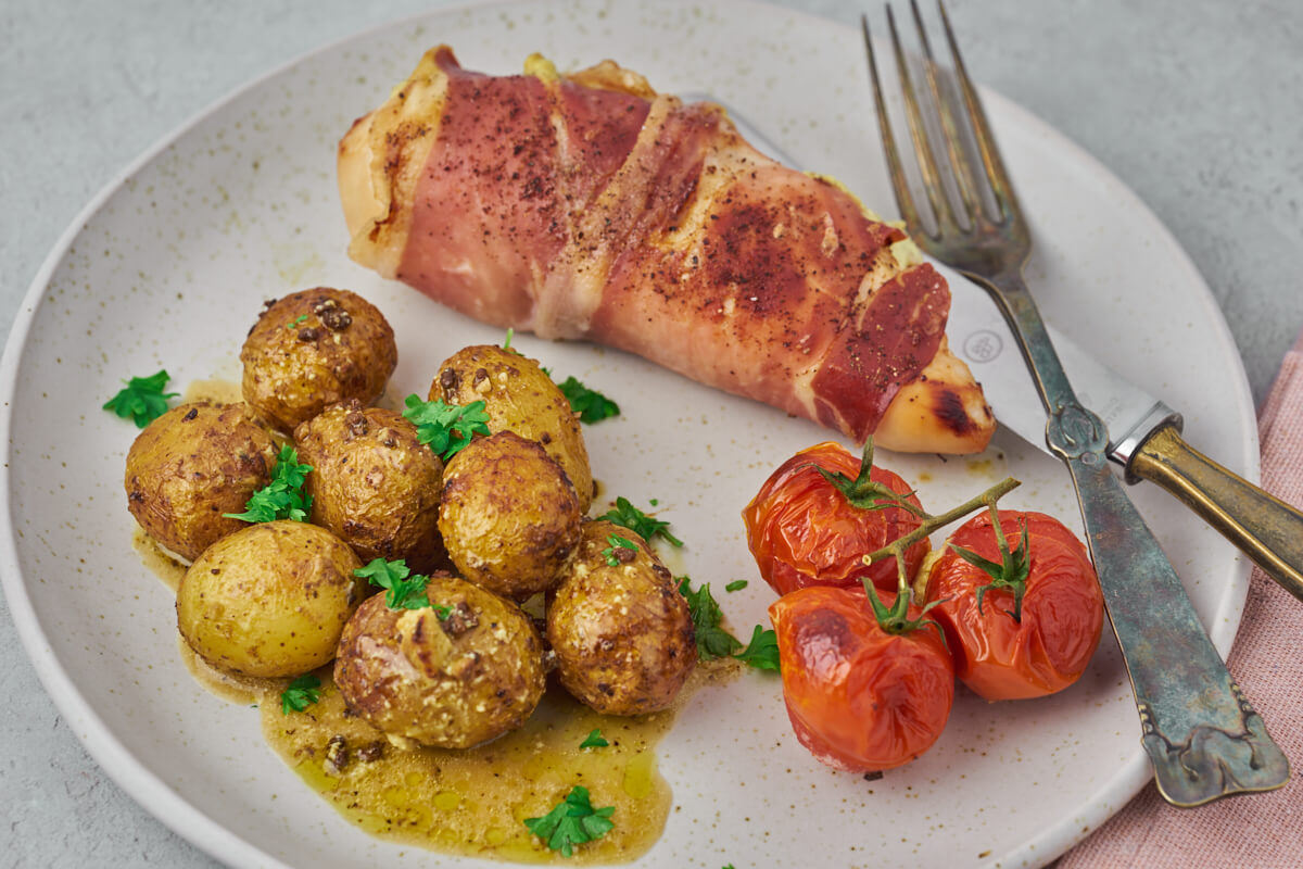 complete meal made in airfryer with stuffed chicken breast, tomatoes and potatoes with pesto