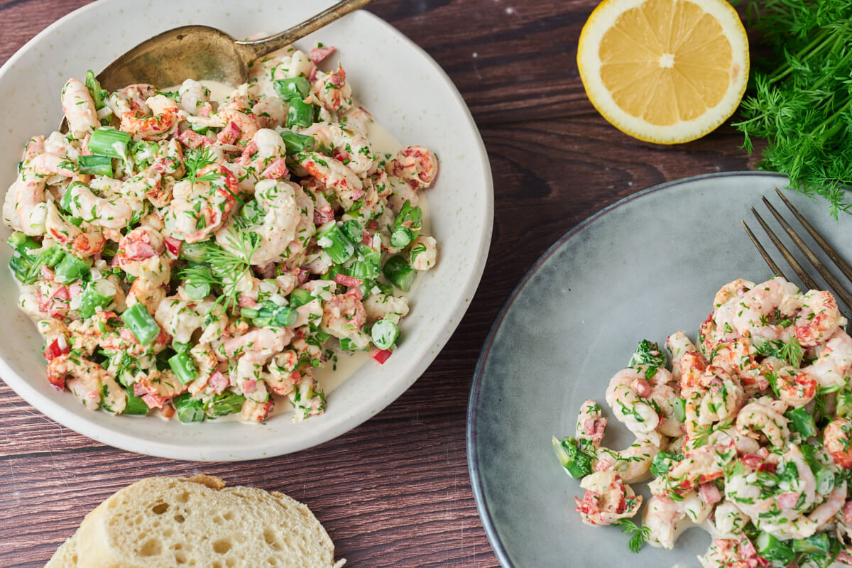 seafood salad in bowl and plate with bread and lemon