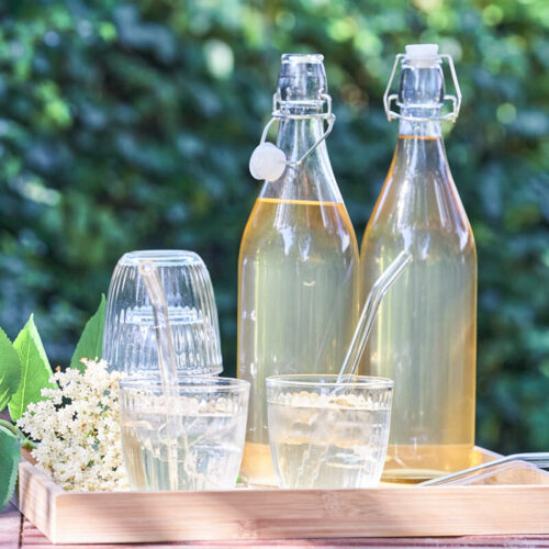 homemade elderflower cordial in glas bottles with drinks