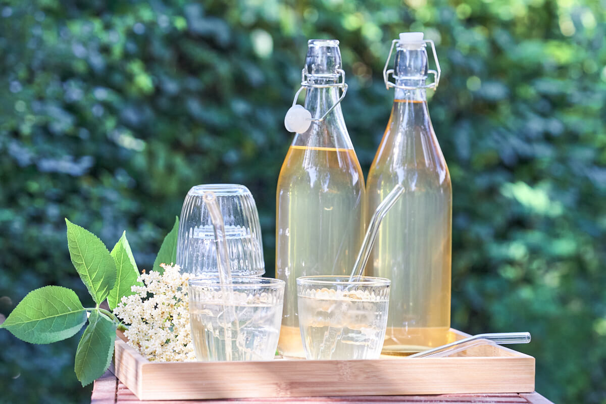 homemade elderflower cordial in glas bottles with drinks