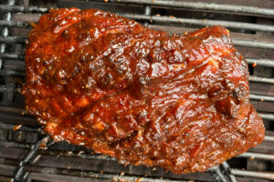 pork collar on the grill with barbecue sauce